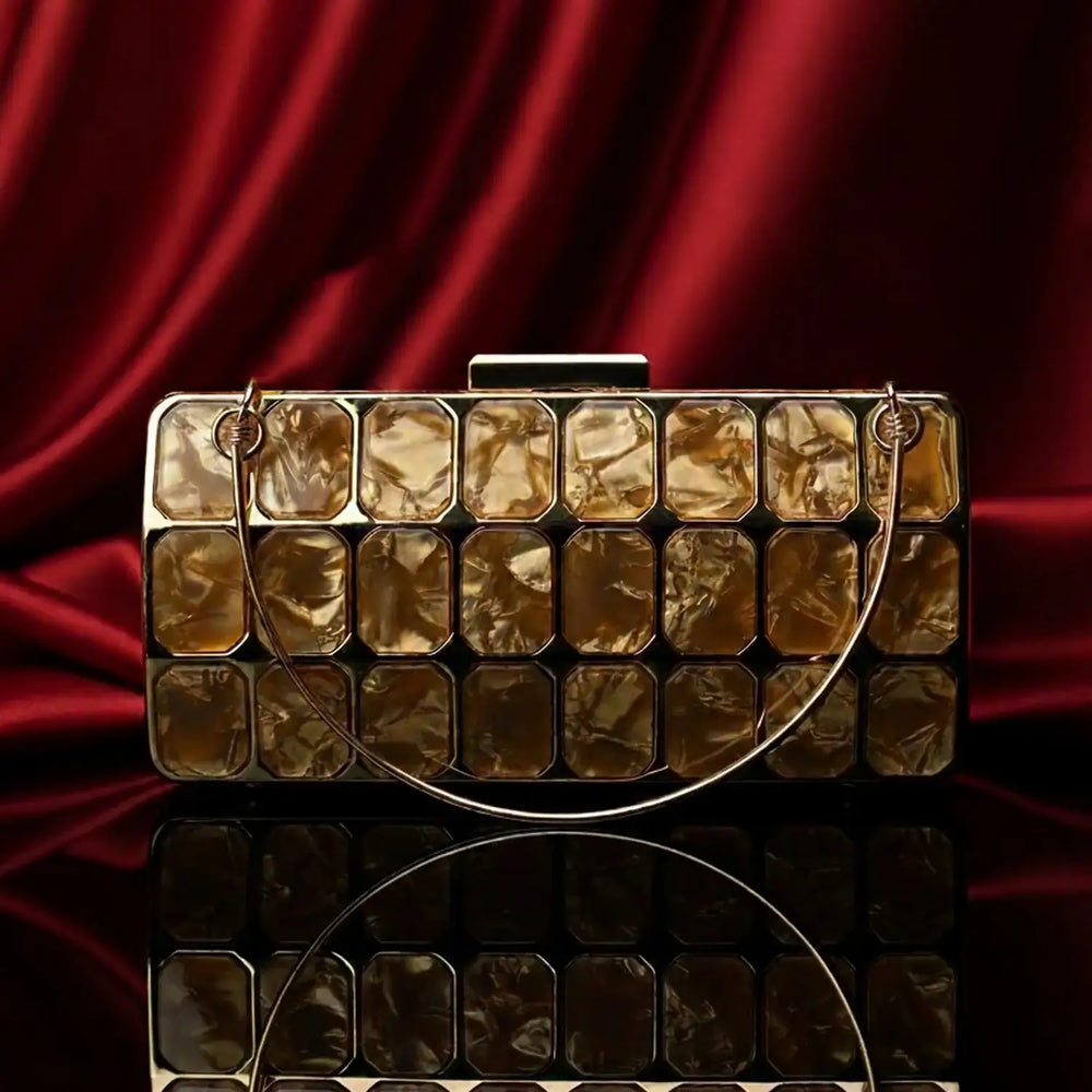 The Manay gold mosaic clutch bag with geometric design on red satin background