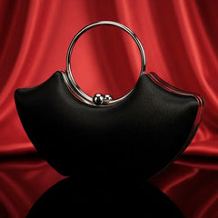 The Manay modern black handbag with silver ring handle on red silk background