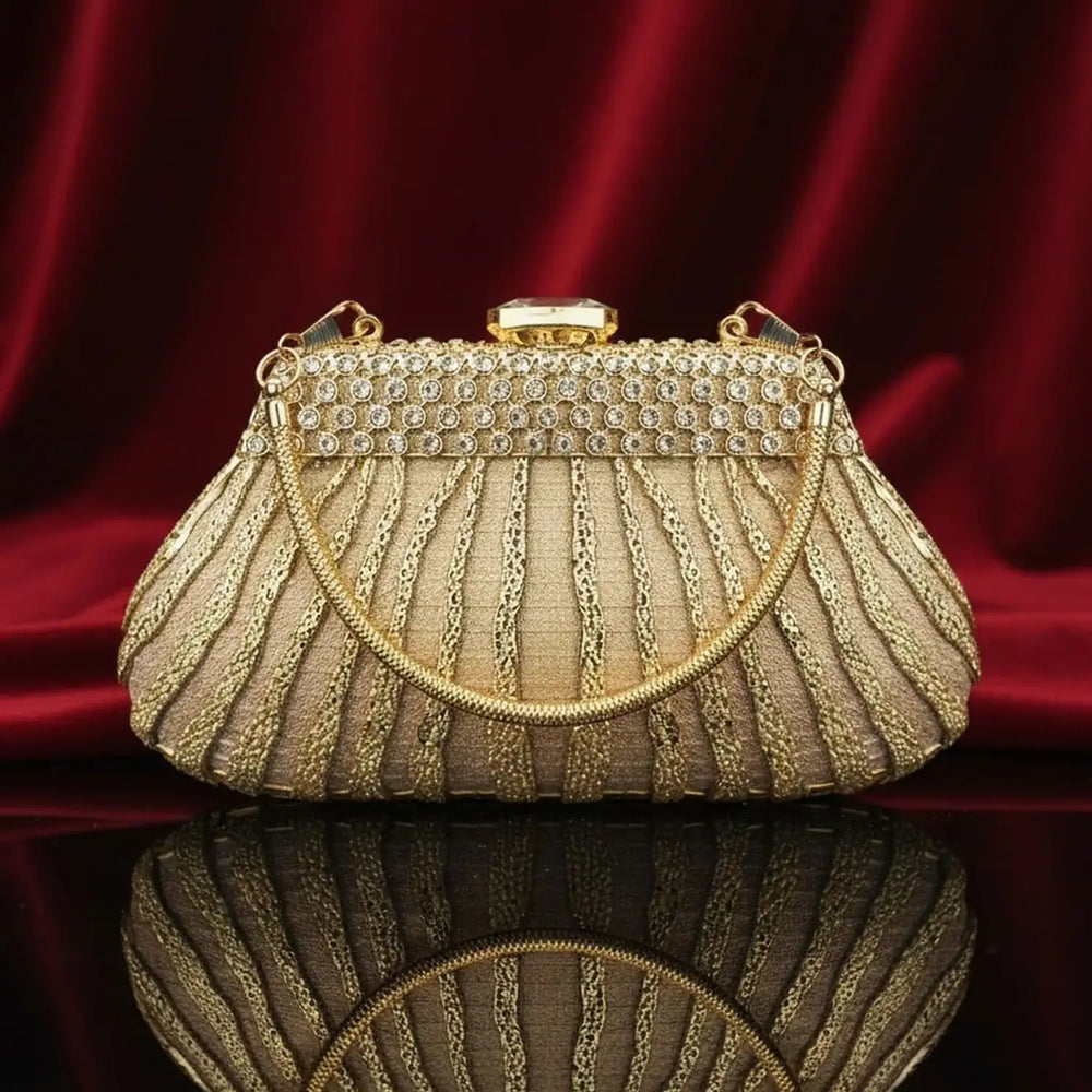 Elegant gold evening clutch purse with rhinestones and chain handle on red velvet by The Manay