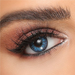 Brilliant Blue colored contact lens on brown eye with bold makeup, ShopLens site product photo