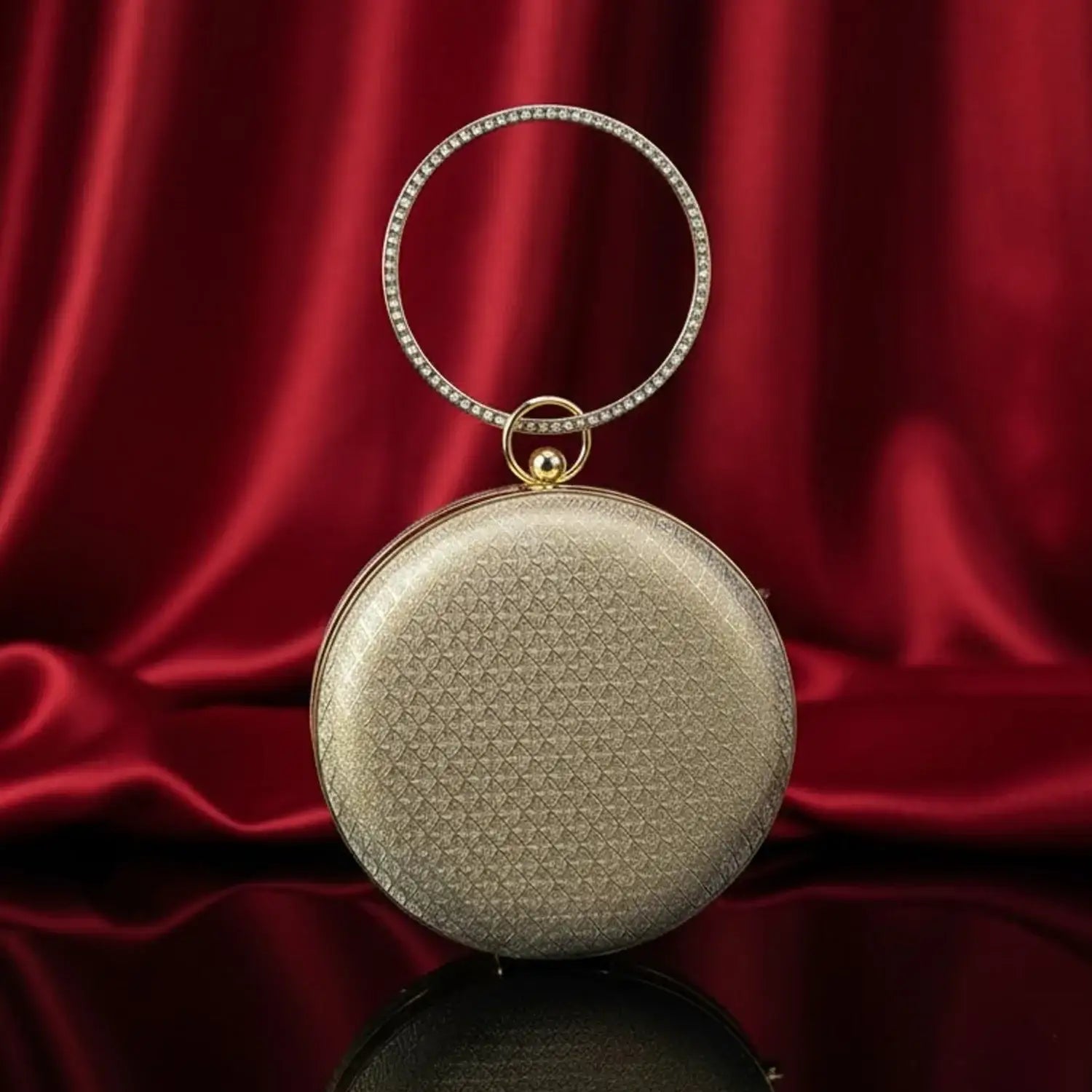 Elegant gold round handbag with jeweled handle on red silk background, The Manay luxury bag