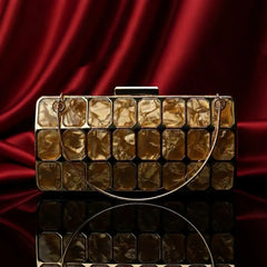 The Manay gold mosaic clutch bag with geometric design on red satin background