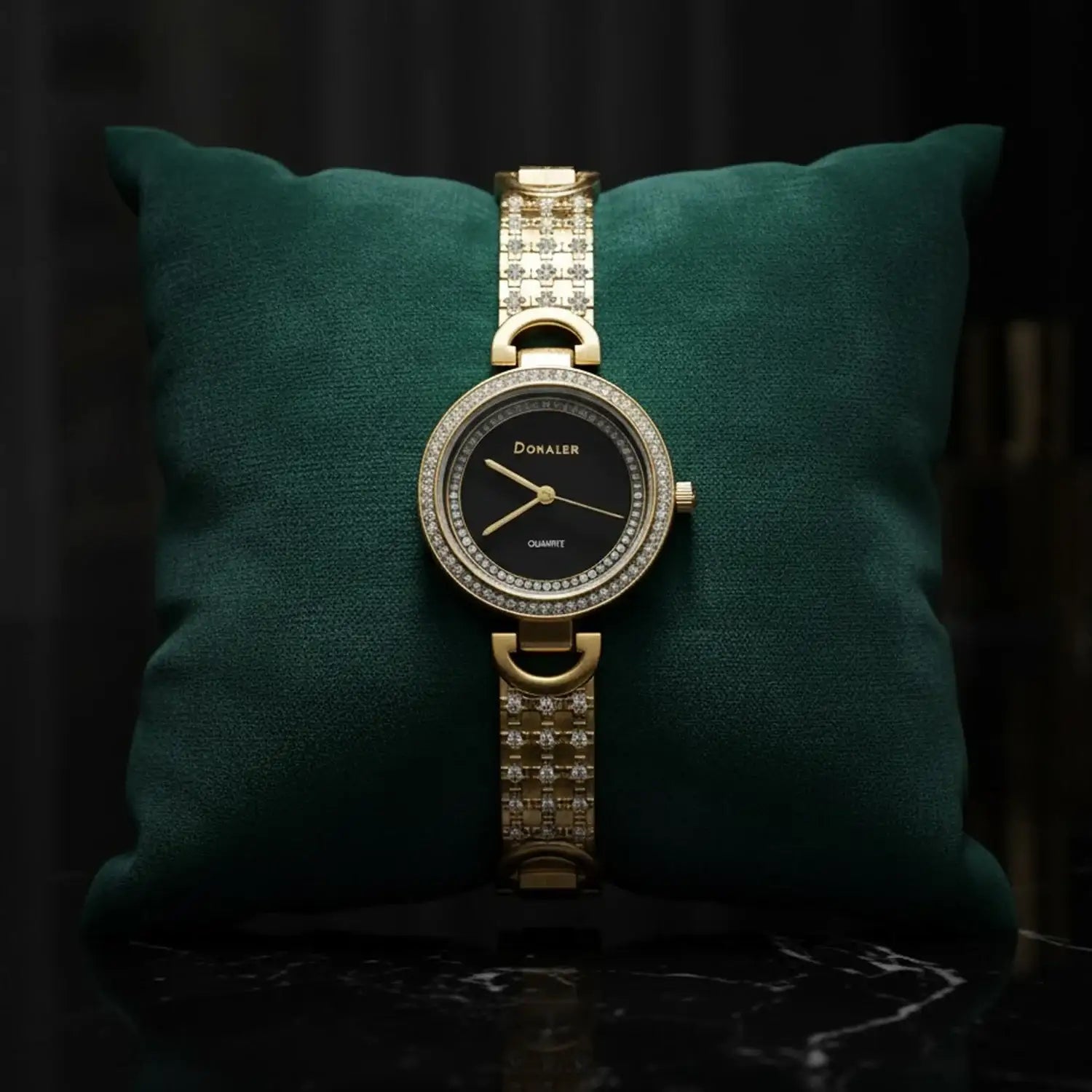 Elegant gold Donaler quartz watch with crystal accents on green cushion, luxury gift at The Manay
