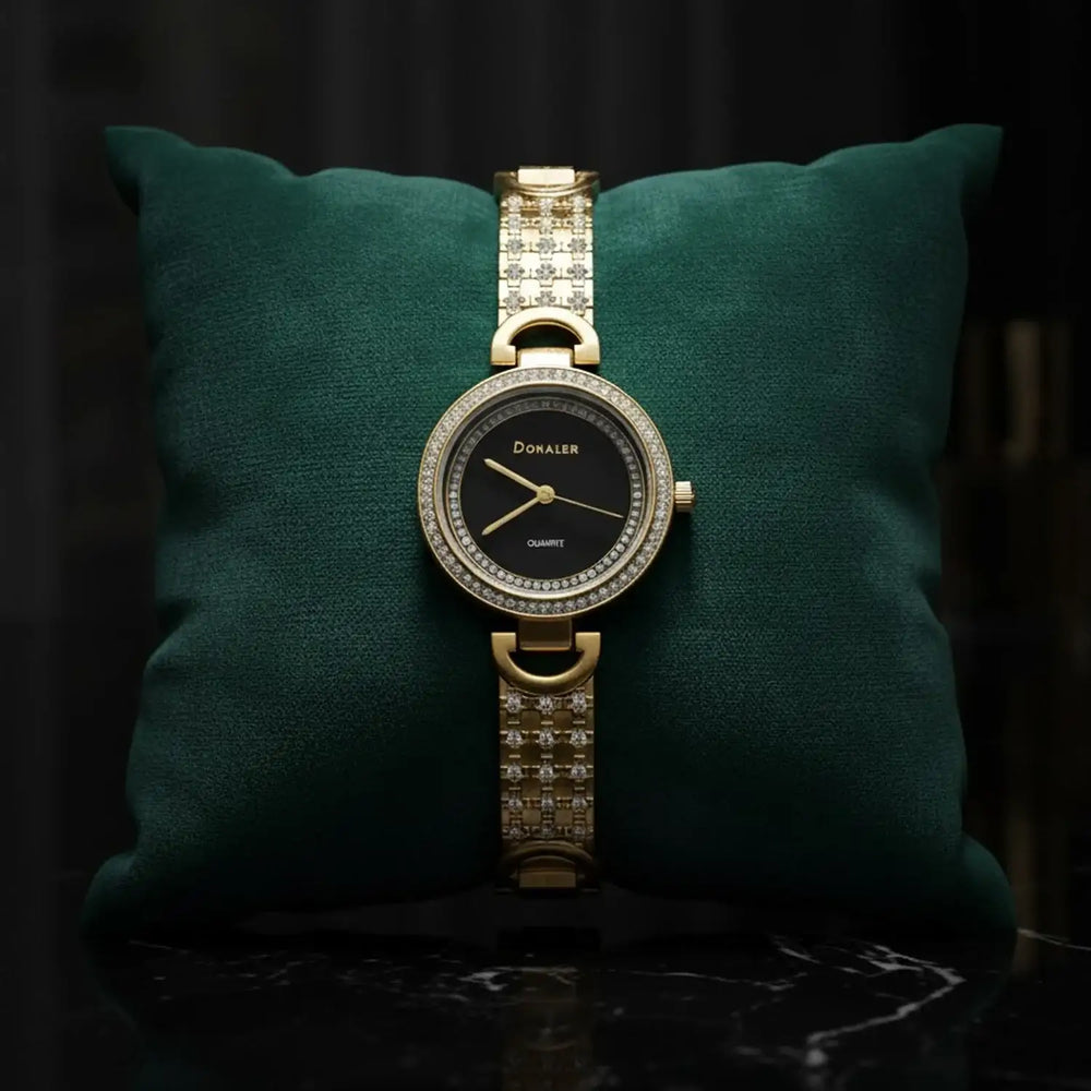 Elegant gold Donaler quartz watch with crystal accents on green cushion, luxury gift at The Manay