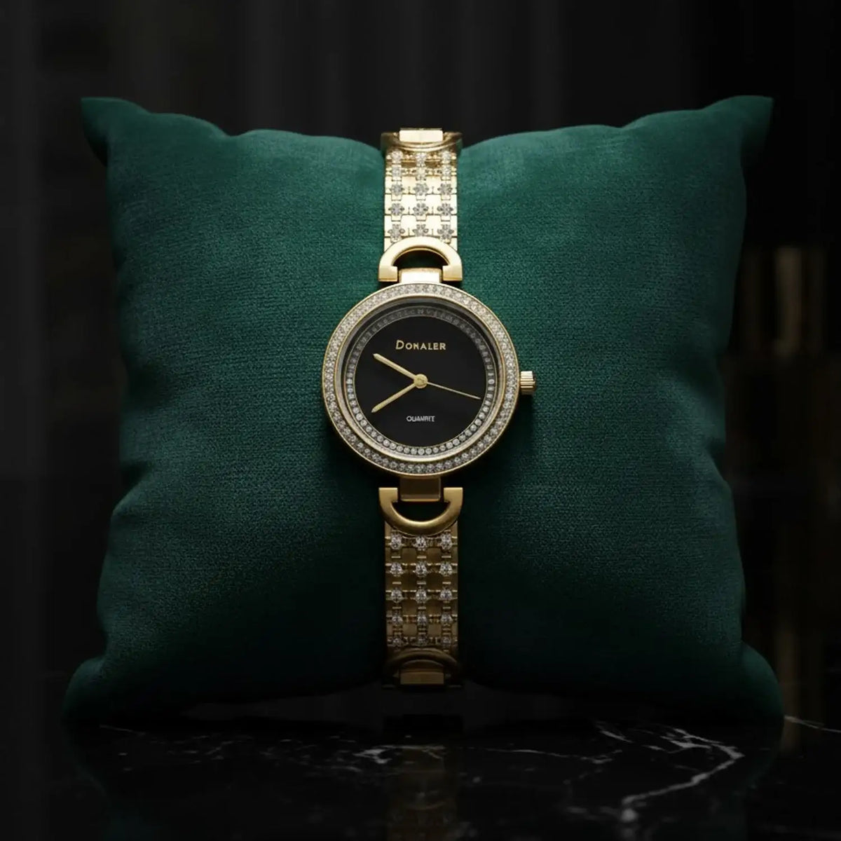 Elegant gold Donaler quartz watch with crystal accents on green cushion, luxury gift at The Manay
