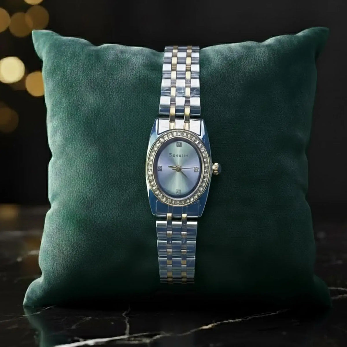The Manay luxury silver and gold wristwatch on green pillow, elegant gift display