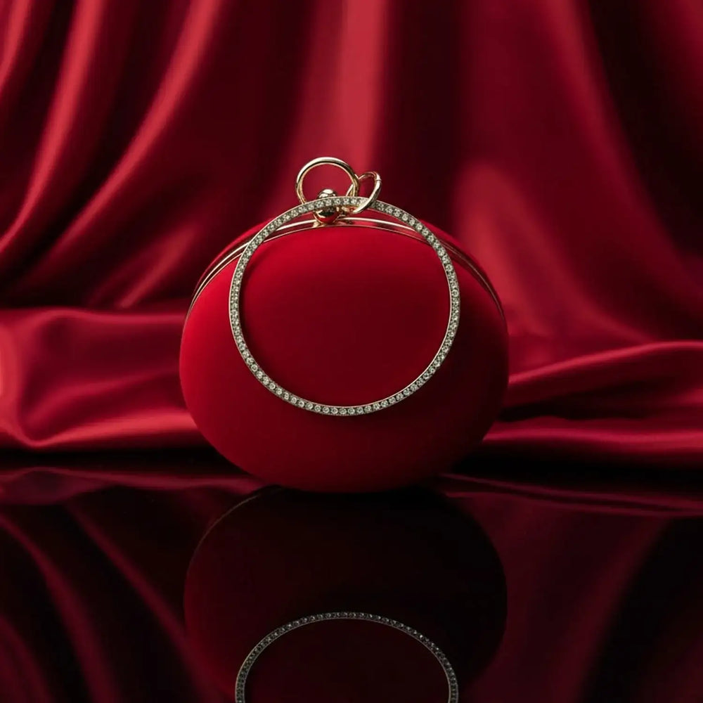 Elegant red velvet round clutch with gold crystal handle on red satin, The Manay